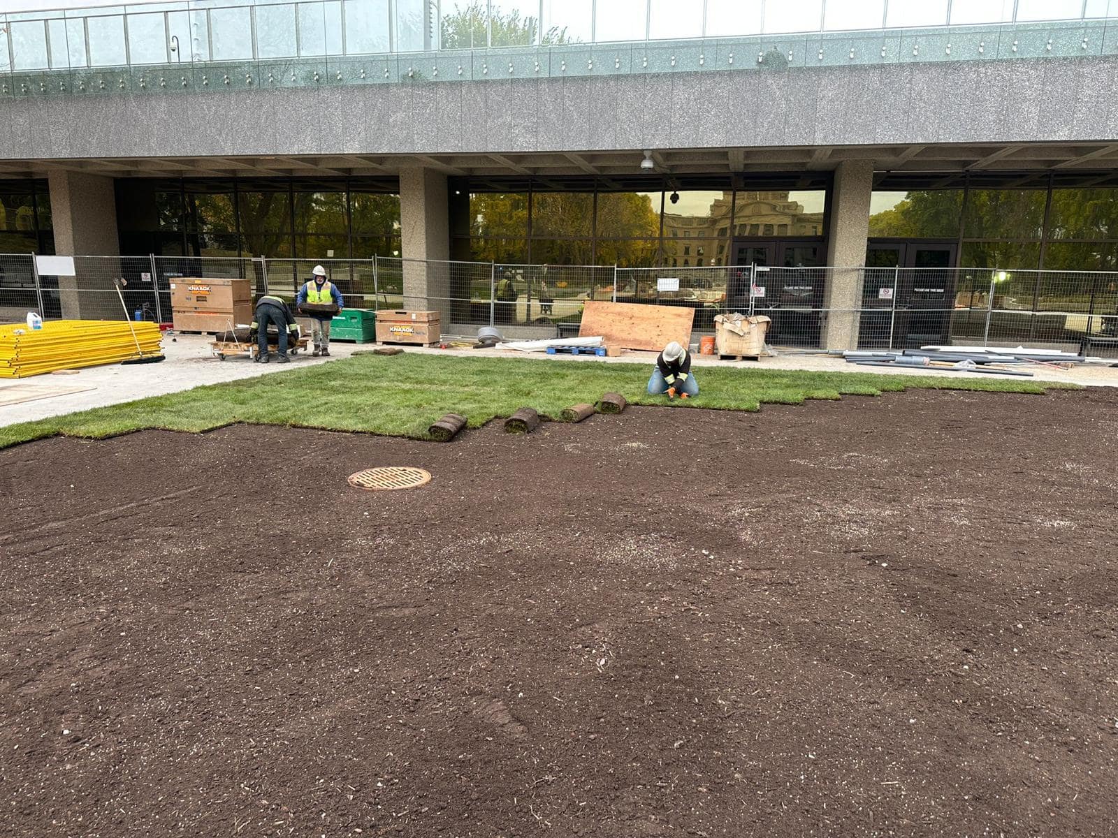 Murat Construction crew rolling out fresh sod in front of a commercial building in Edmonton